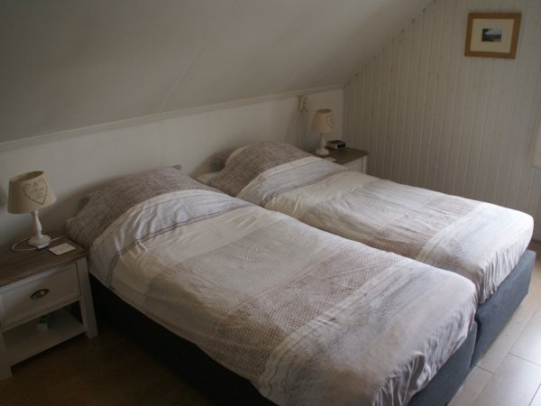 Een van de tweepersoonskamers boven met wastafel